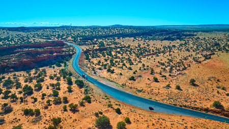 Aerial Winding Highway Through Desert with Truck and Car Motion Fly Throughの写真素材