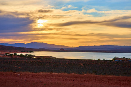 Desert Lake at Sunset with Silhouette Mountains and Dramatic Sky Eye Level Viewの写真素材