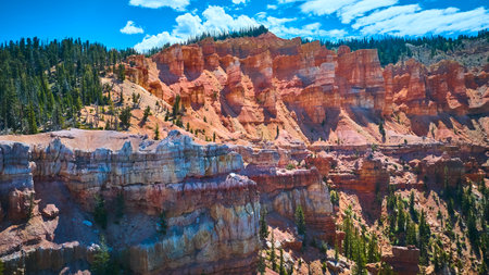 Aerial Red Rock Formations Pine Forest and Cliffs in Sunlit Mountain Landscapeの写真素材