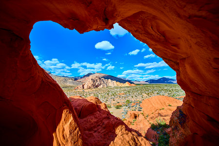 Red Sandstone Arch Formation Framing Desert Landscape in Nevadaの写真素材