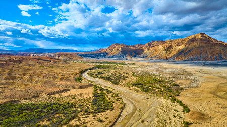 Aerial Desert Cliffs and Winding Riverbed with Dramatic Clouds Utah Wilderness