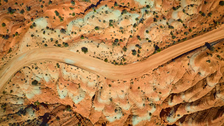Aerial Top Down Desert Road Winding Through Colorful Rock Formations Utahの写真素材