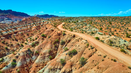 Aerial Winding Dirt Road Through Arid Hills and Mesas in Paria Utahの写真素材