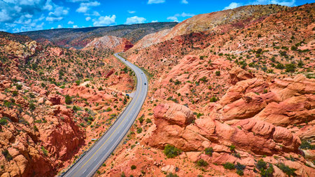 Aerial Desert Highway with Red Rock Formations and Vehicles Utahの写真素材