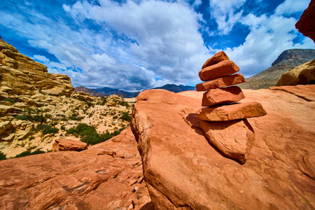 Rock Cairn on Red Sandstone with Dramatic Desert Landscape and Blue Skyの写真素材