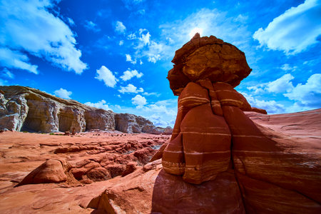 Toadstool Hoodoo Sandstone Formation with Sunlit Red Cliffs and Blue Sky Utahの写真素材