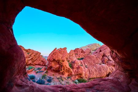 Red Rock Arch Formation and Rugged Desert Landscape under Clear Blue Sky