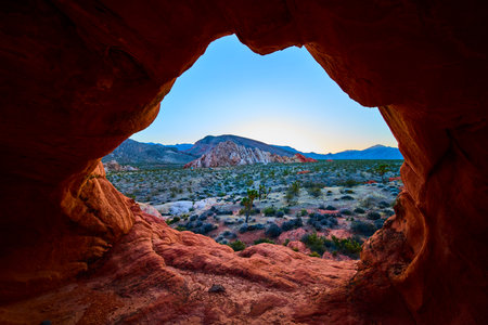 Desert Landscape Framed by Red Sandstone Arch Formation at Sunrise in Nevadaの写真素材