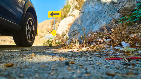 Ground Level Car Tire Rocky Roadside and Turn Sign in California Mountains