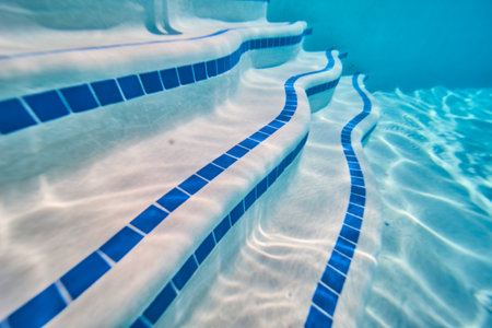 Underwater Pool Steps with Blue Tile and Sunlight Patterns in Neighborhood Settingの写真素材