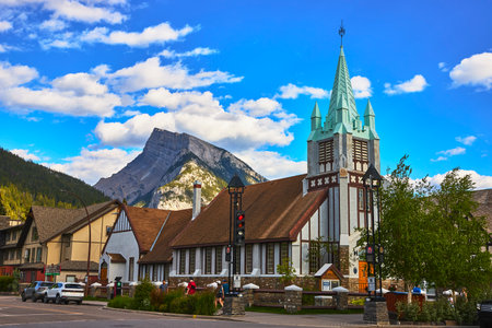 Historic Church and Mountain Landscape in Town of Banff Canada Under Blue Skyの写真素材