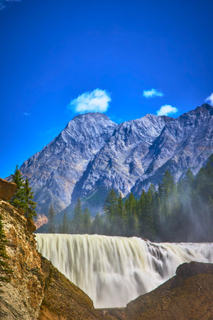 Wapta Falls Waterfall with Majestic Mountain and Evergreen Forest in Yoho National Parkの写真素材