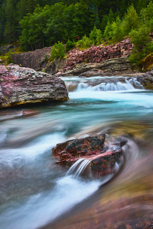 Red Rock Cascade and River Flow with Forest at Glacier Montana