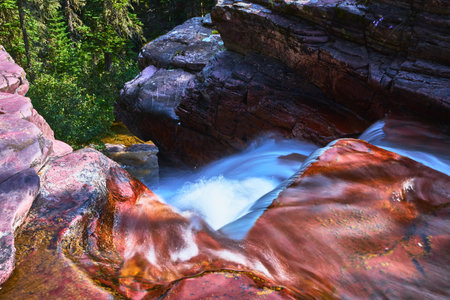 Waterfall Cascading Over Red Rocks and Forest on Scenic Trailの写真素材