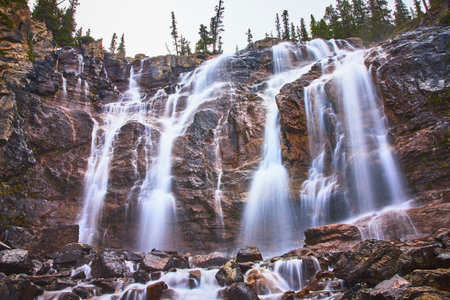 Tangle Falls Waterfall Cascading Over Rocky Cliffs with Lush Forest Jasper Canadaの写真素材