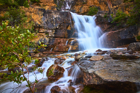 Tangle Falls Waterfall Flowing Over Rocky Cliffs with Greenery in Jasper Canadaの写真素材
