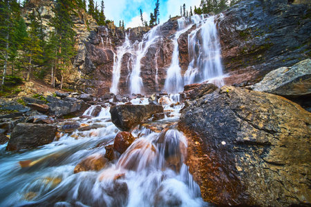Tangle Falls Waterfall Flowing Over Rocky Cliff with Evergreen Forest in Jasperの写真素材