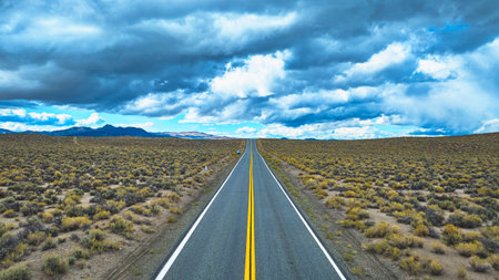Aerial Highway 120 Road Through California Desert Under Dramatic Clouds