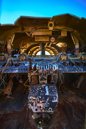 Abandoned Airplane Cockpit with Graffiti and Exposed Wiring in Desert Sunlight