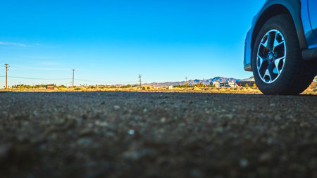 Ground Level Vehicle Tire Desert Landscape and Small Town Baker Californiaの写真素材