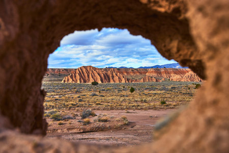 Natural Rock Arch Framing Cathedral Gorge Desert Landscape and Dramatic Sky