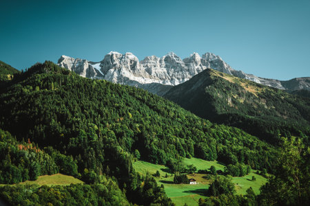 Majestic mountains in the Alps covered with trees and cloudsの写真素材