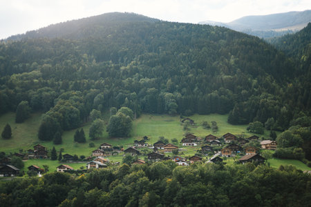 Majestic mountains in the Alps covered with trees and cloudsの写真素材