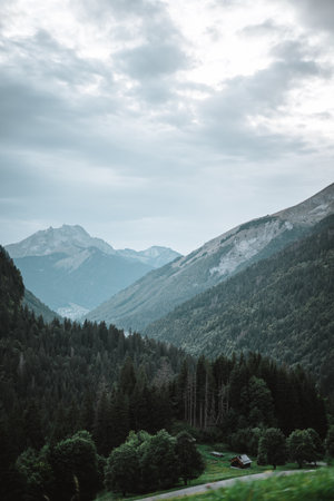 Majestic mountains in the Alps covered with trees and cloudsの写真素材