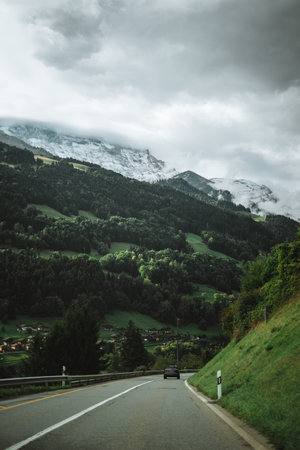 Majestic mountains in the Alps covered with trees and cloudsのeditorial素材
