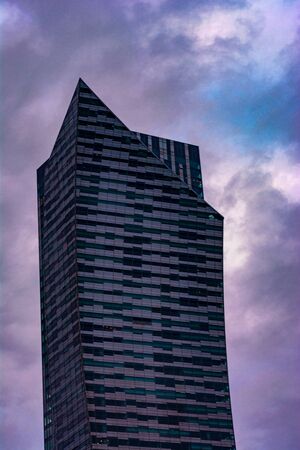 Warszaw, Poland, October 18, 2018: gray skyscraper on a background of dark gray sky dayのeditorial素材