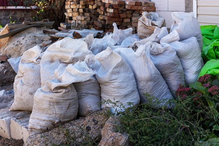 white bags with construction debris on streetの写真素材