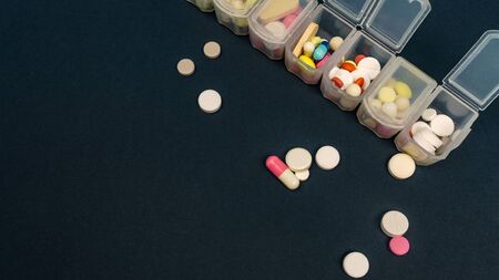 plastic organizer for tablets. tablets are red, white, round. close-up