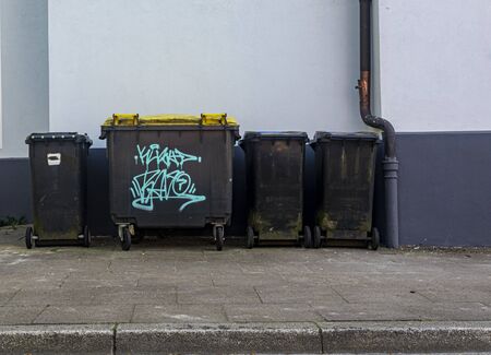 black plastic trash containers street by day closeupの写真素材
