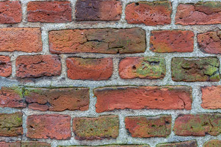 Background old masonry of red brick. Plaster, concrete, cement. Cracks, peeling, voids. Close-upの写真素材