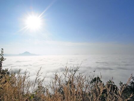 Clouds above mountain, beneath the sun.の写真素材