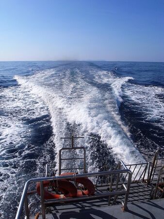 Speed boat leaving with a bow wave.の写真素材