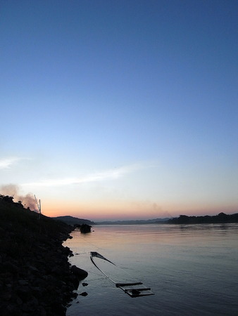 Sinking boat in the river at sunset.の写真素材