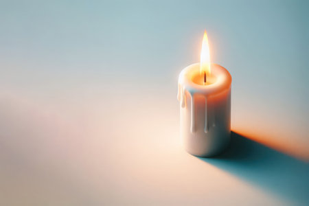 A burning single candle on a clean background. Space for textの素材