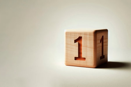 A wooden cube with the number one on a light background. Space for textの素材