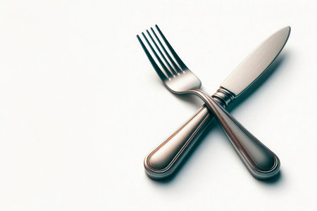 The knife and fork are folded crosswise on a light background. Space for textの素材