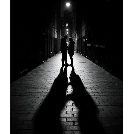 Silhouette of a couple in a night alley under street lightの素材