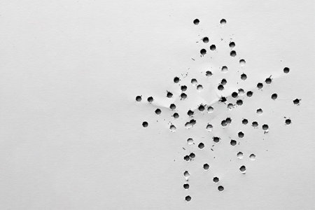 Multiple holes or holes in the white surface. Space for textの素材