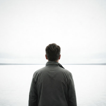 A man looks into the distance against the gray horizonの素材
