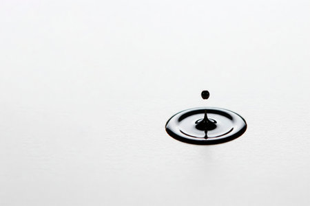 A drop of liquid falls into the center of the white surface. Space for textの素材