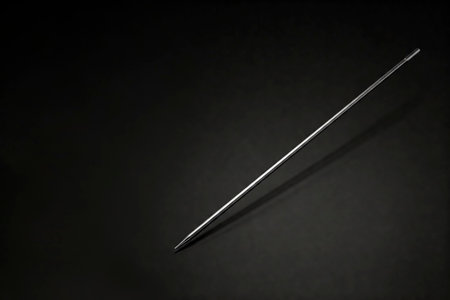 A metal needle on a black background. Space for textの素材