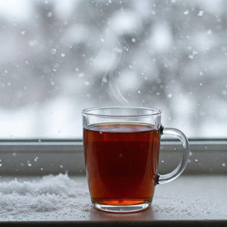 A cup of hot tea against the background of a winter windowの素材