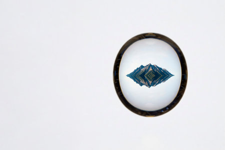 Mountains reflected in a crystal ball on a white background. Space for textの素材