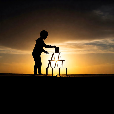 Silhouette of a child building a house of cards at sunsetの素材