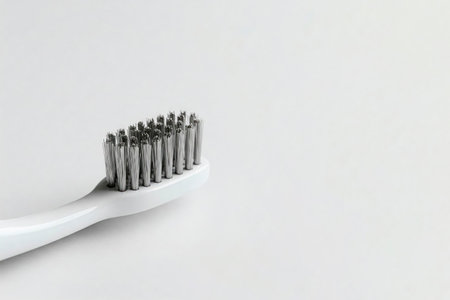 Toothbrush with metallic bristles on a light background. Space for textの素材