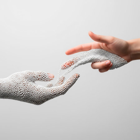 A hand made of balls crumbles, touching a real handの素材